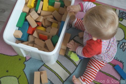 Baby sitzt und spielt mit Bauklötzen