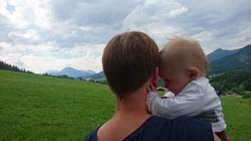 Mutter mit Baby vor Bergkulisse